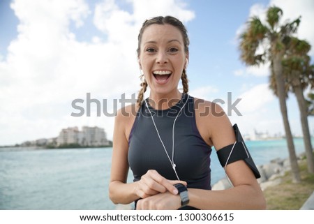 Happy athletic woman in sportswear smiling at personal best