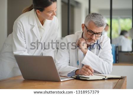 Medical people working together on patient file, hospital office