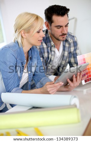 Middle-aged couple choosing wall colours for new home