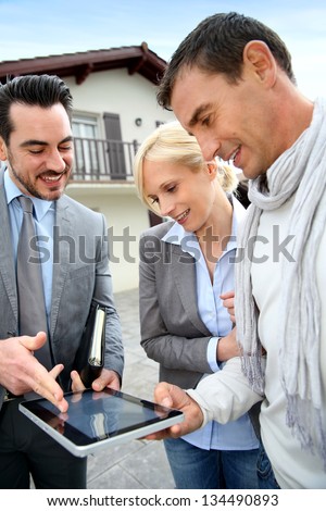 Real-Estate-Agent Showing House Plan On Digital Tablet