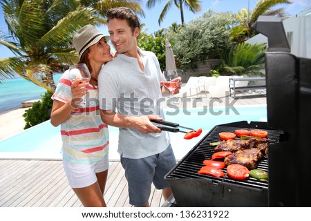 Cheerful Couple In Holidays Preparing Grilled Meat