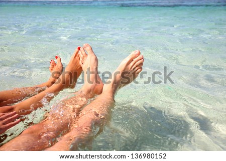 Closeup of couple\'s feet in lagoon water