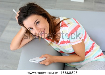 Young woman using smartphone sitting in sofa