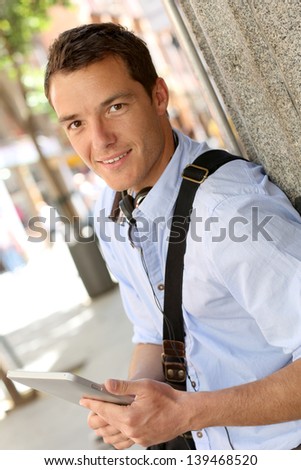 Casual man in town using digital tablet