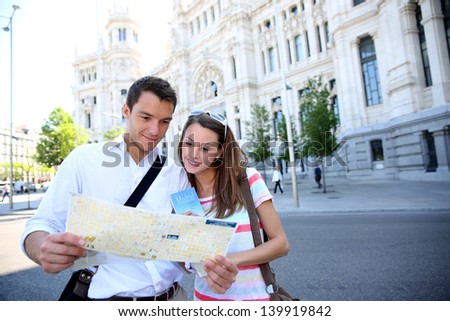 Tourists reading map in front of Palacio de Comunicaciones