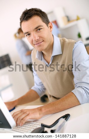 Man working in office in front of desktop computer