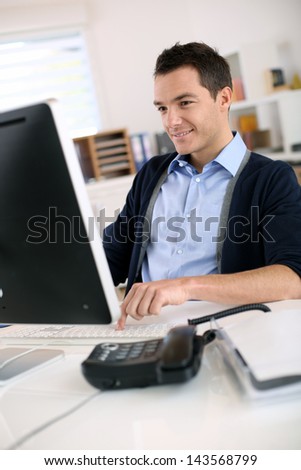 Man working in office in front of desktop computer