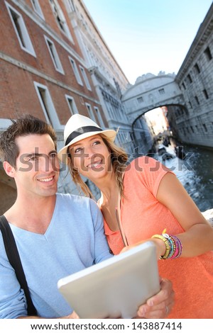 Couple looking at tourist guide by the Bridge of Sighs, Venice