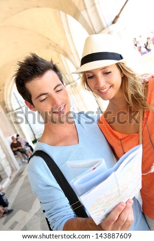 Couple in Venice reading map under the arcades of Palazzio Ducale