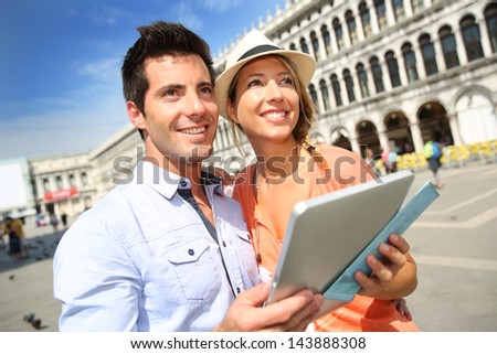 Couple in Venice looking at tourist information on tablet