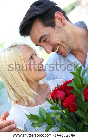 Man giving red roses to woman