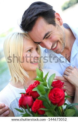 Man giving red roses to woman