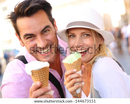Cheerful couple in Rome eating ice cream cones