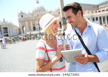 Couple of tourists using digital tablet in Rome