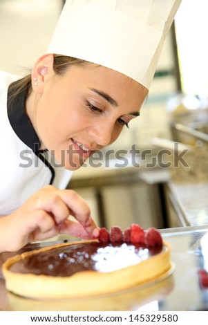 Cheerful girl at training school making cake