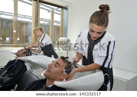 Young women in hair salon washing customer\'s hair