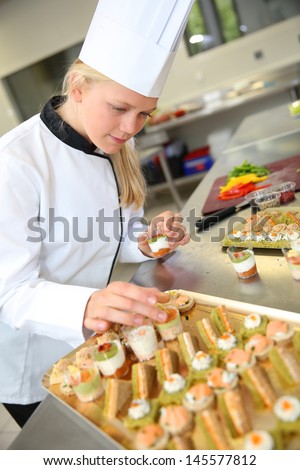 Young caterer preparing tray of appetizer