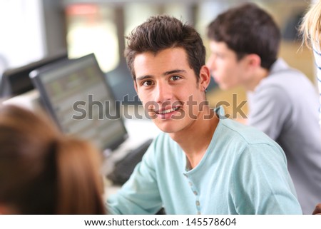 Smiling teenaged boy in computing class