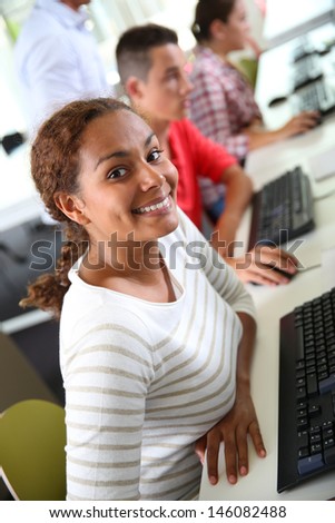 Smiling student girl sitting in computing class