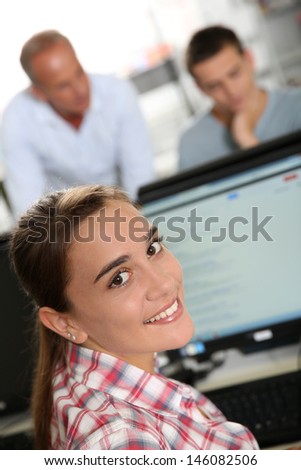 Smiling student girl in front of desktop