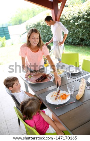 Mom serving grilled food to children
