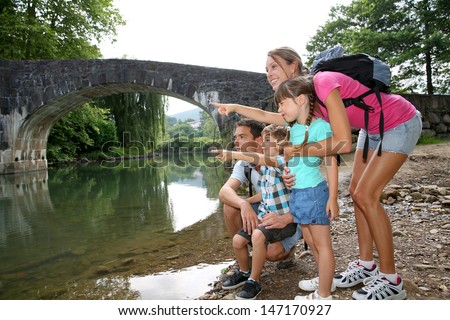 Family on a hiking journey standing by the river