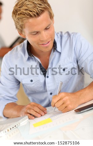 Portrait of smiling attractive young man in office