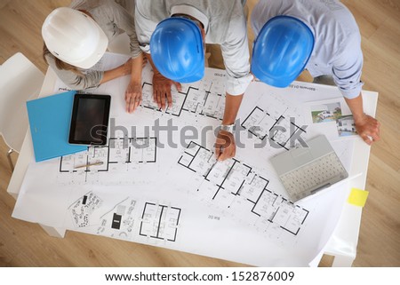 Upper View Of Architects Working On Blueprint