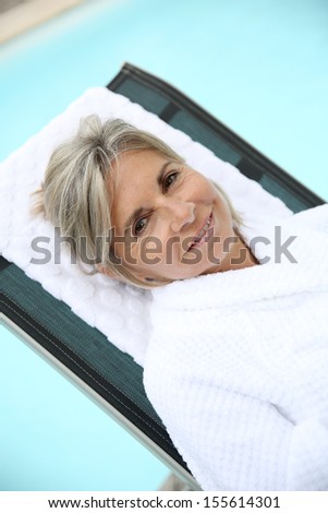 Senior woman in spa hotel relaxing in long chair