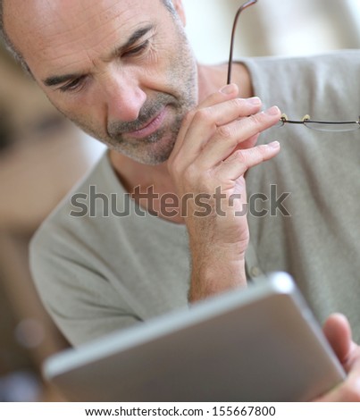 50-year-old man using digital tablet