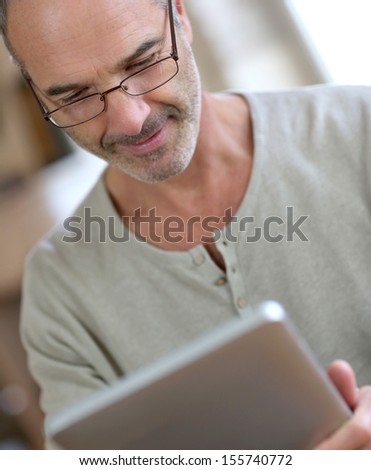 50-year-old man using digital tablet