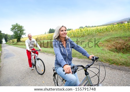 Senior Couple Riding Bicycle In Countryside