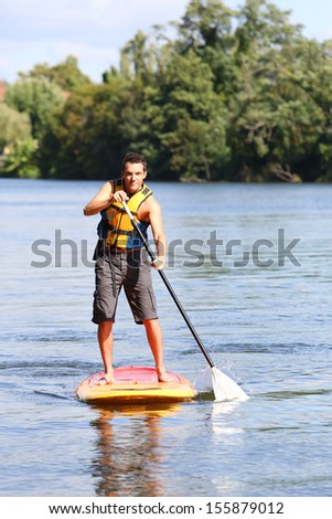 Mn riding stand-up-paddle in river