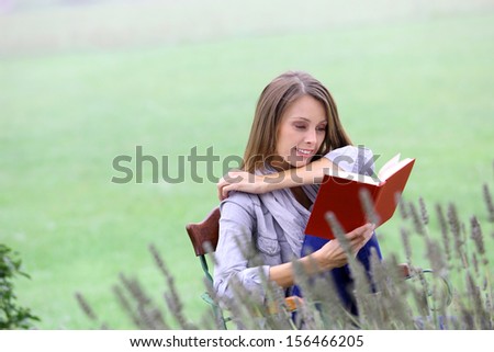 Portrait of beautiful woman reading book in nature
