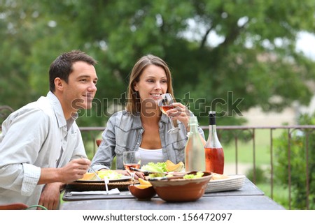 Cheerful couple having lunch in hotel garden
