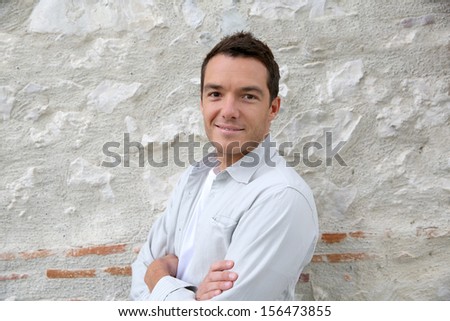 Smiling handsome man leaning on wall