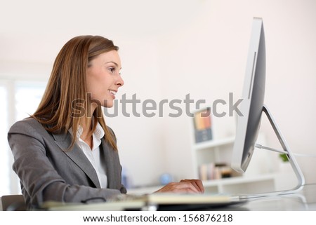 Saleswoman in office working on desktop computer