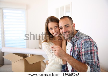 Happy couple in their new home holding key