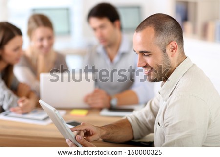 Young man in office working on digital tablet