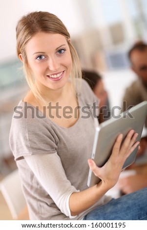 Beautiful young woman at work using tablet