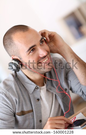 Trendy guy listening to music wiith headset on