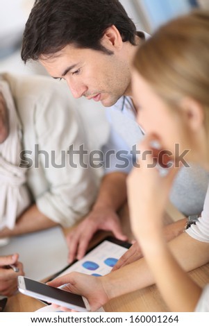 Business meeting around table with electronic devices