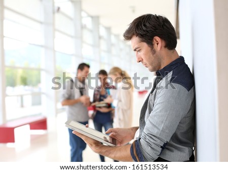 Young Man In College Campus Connected On Tablet