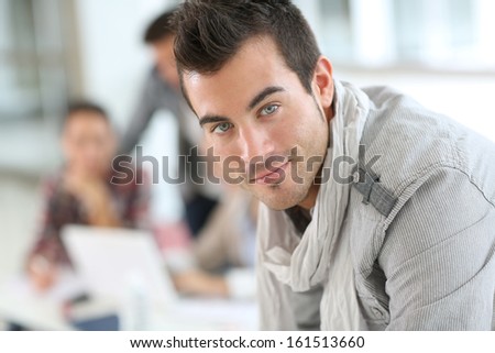 Portrait of smiling student guy in class