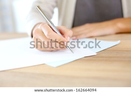 Closeup of woman\'s hand writing on paper