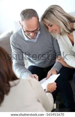 Senior couple meeting financial adviser for investment