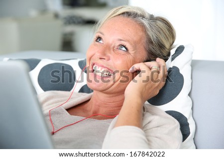 Attractive woman listening to music relaxed on sofa