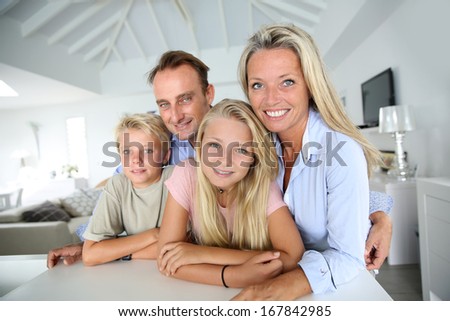 Happy family of four looking at camera