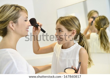 Little girl playing with her mom\'s makeup