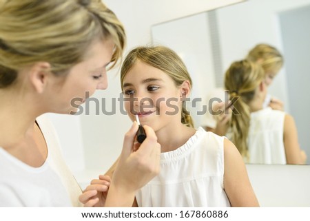 Little girl playing with her mom\'s makeup